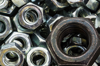 Macro metal nuts with a difference. Metal nuts big black and small silver.